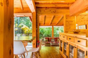 una cocina con mesa y sillas en una cabaña en BOG Arken - Casa junto al río en Villa La Angostura