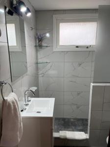 Un baño blanco con lavabo y espejo. en El Horreo Apart, en Villa Gesell 22 fotos más