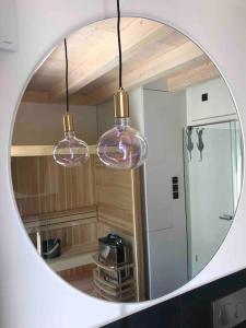 a mirror in a kitchen with three glass lights at eifelhausaufzeit-Vulkaneifel-Architekten-Chalet mit Sauna im Vulkankrater in Immerath +51 photos