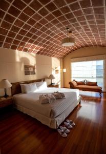 a bedroom with a large white bed with aamed ceilings at BTH Hotel Arequipa Lake in Arequipa