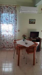 a dining room with a table and a piano at Lampros apartments in Loutra Edipsou