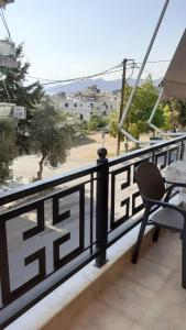 a table and a chair on a balcony with a view at Lampros apartments in Loutra Edipsou