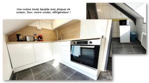 a kitchen with white cabinets and an oven at Sous les toits – tout confort in Saint-Brieuc