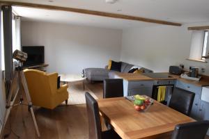 eine Küche und ein Wohnzimmer mit einem Holztisch und einem Esszimmer in der Unterkunft Cowshed in the Black Mountains in Abergavenny