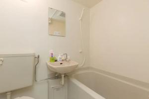 a white bathroom with a sink and a bath tub at HOTEL LUCKY - Vacation STAY 49954v in Osaka