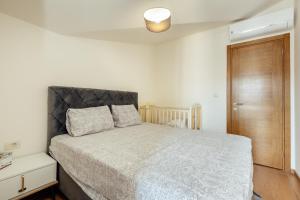 a bedroom with a bed and a wooden door at Pool résidence apartment Tivat in Tivat +21 photos