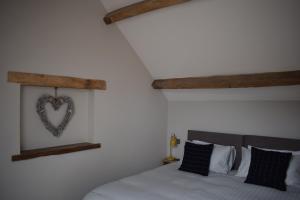 a bedroom with a bed with a heart on the wall at Cowshed in the Black Mountains in Abergavenny