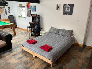 a bedroom with a bed with two red pillows on it at The Dog House in Birkenhead