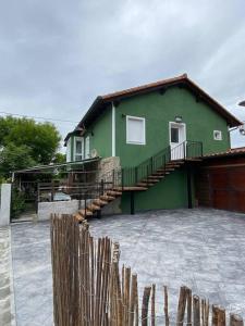 una casa verde con una valla delante en Casa Berzoso en Gajano en Gajano