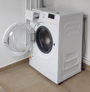 uma máquina de lavar roupa branca ao lado de uma máquina de lavar roupa em Apartment Iris bedroom living and parking voucher vacanță em Baia Mare