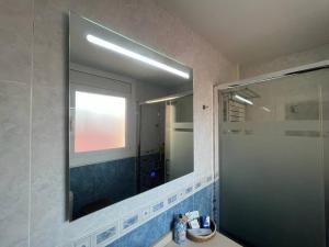 Ático luminoso céntrico y cómodo في فيغيراس: حمام مع مرآة كبيرة ومغسلة