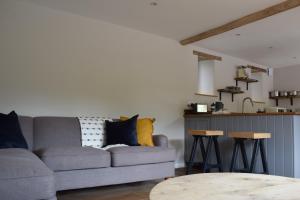 sala de estar con sofá y mesa en Cowshed in the Black Mountains, en Abergavenny
