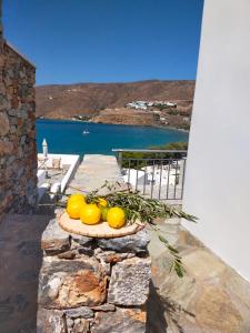 a plate of fruit sitting on a stone wall at Amorgos Elegant Houses, 6 Villas in Amorgos