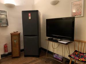 a black refrigerator and a television in a room at Townhouse 26 Chambres d'Hôtes Civray Hotel in Civray