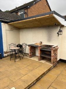 a patio with a grill and a table and chairs at The Dog House in Birkenhead