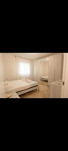 biały pokój z 2 łóżkami i oknem w obiekcie Apartment Angy w mieście Mira