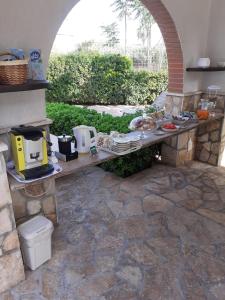 uma mesa ao ar livre com comida num pátio de pedra em Villa Lina Bed&Breakfast em Taranto