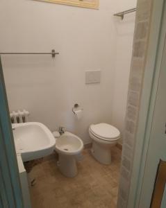ein weißes Bad mit einem WC und einem Waschbecken in der Unterkunft La Quercia in Colle Farnese