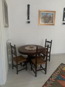 einen Esstisch mit 2 Stühlen, einem Tisch und einem Bild in der Unterkunft La Quercia in Colle Farnese