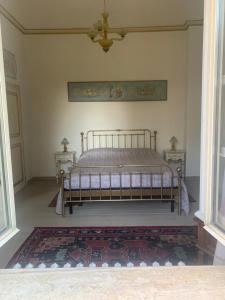 Bett in einem Zimmer mit 2 Tischen und einem Teppich in der Unterkunft La Quercia in Colle Farnese