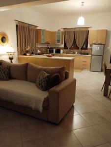 ein Wohnzimmer mit einem Sofa und einer Küche in der Unterkunft Margeo house in Perdika