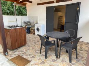 een keuken met een tafel en stoelen en een fornuis bij Joli studio 30m2 rte de St Jean tout confort 