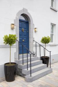 Townhouse Stay - St George's Terrace في كاريك اُن شانون: الباب الأزرق والدرج أمام المبنى