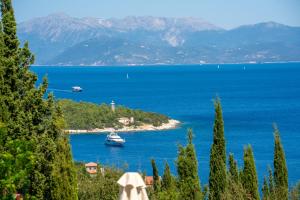 a boat in a large body of water with mountains at Garden House, up to 8px 1km from Fiskardo in Tselendáta