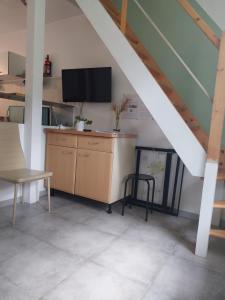 ein Wohnzimmer mit einem TV und einem Schreibtisch mit einem Stuhl in der Unterkunft Au fil de l'eau in Rohan