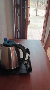 a tea kettle sitting on top of a table at Amarula Tree Hotel in Mikumi