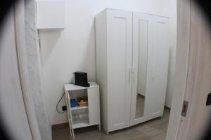 a white cabinet with a mirror in a room at Tiny House Bari in Bari
