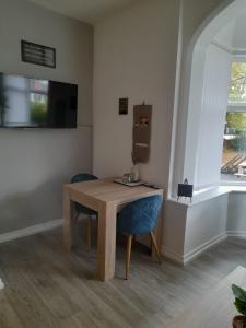 Habitación con mesa de madera y silla azul. en Flat 5 Corner House 1 bedroom en Doncaster