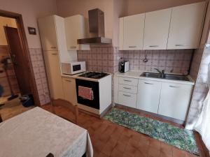 een keuken met witte kasten en een fornuis met oven bij CasaUmberto in Nizza Monferrato