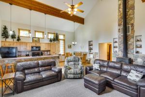 sala de estar con muebles de cuero y chimenea de piedra. en Spacious Beaver Getaway Near Eagle Point Resort!, en Beaver