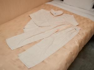 那霸的住宿－Grand Cabin Hotel Naha Oroku - Vacation STAY 46864v，白色衬衫躺在床上