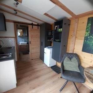 a kitchen with a table and a chair in a room at Tiny House am Steinergut in Radstadt