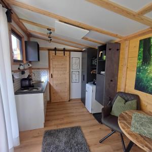 eine Küche und ein Wohnzimmer mit einem Tisch und Stühlen in der Unterkunft Tiny House am Steinergut in Radstadt