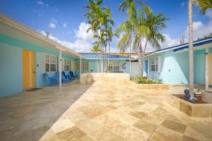 a house with a patio with palm trees in front of it at La Mer Suites in Fort Lauderdale