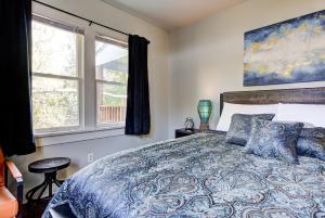 a bedroom with a bed with a blue comforter and two windows at Putnam Pad II - City card 4 local biz discount in Oklahoma City