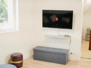 sala de estar con TV de pantalla plana en la pared en Le coup de coeur d'Honfleur, en Équemauville
