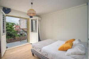 Schlafzimmer mit einem Bett und Blick auf einen Balkon in der Unterkunft Foyal City Center in Fort-de-France