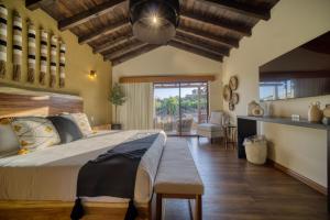 a bedroom with a large bed and a dining room at Emmalu Hotel Boutique in San Marcos