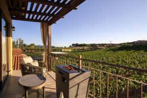 ein Balkon mit Tisch und Stühlen und ein Weinberg in der Unterkunft Emmalu Hotel Boutique in San Marcos