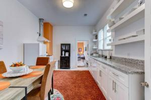 a kitchen with white cabinets and a table with an orange rug at Clementine Bungalow Downtown Hot Springs in Hot Springs