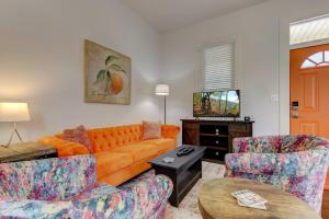 a living room with an orange couch and two chairs at Clementine Bungalow Downtown Hot Springs in Hot Springs