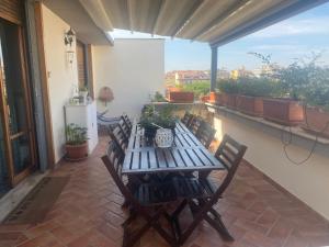 patio con mesa de madera y sillas en el balcón en La casa di Dani, en Florencia