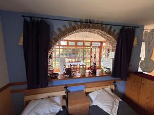 a room with a window with an arch over a bed at Cal Tià in Viliella