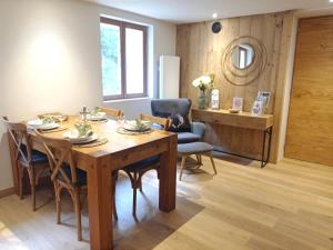 comedor con mesa de madera y sillas en *Spacieux T3 Campagne proche lac*, en Magland