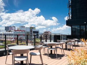 a row of tables and chairs on the roof of a building at REF Kanku-Izumisano by VESSEL HOTELS in Izumi-Sano