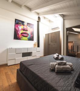 1 dormitorio con 1 cama grande y una pintura en la pared en Luxury industrial apt vicino al centro con garage, en Brescia